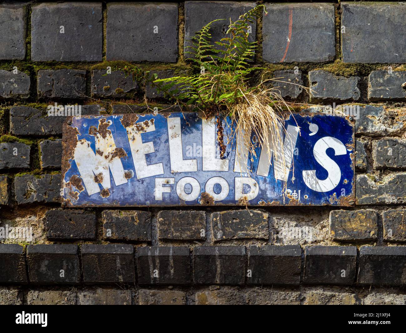 Antikes rostblaues und weißes Emailschild für Mellins Essen an einer Außenwand in der Torrens Street. London. Stockfoto