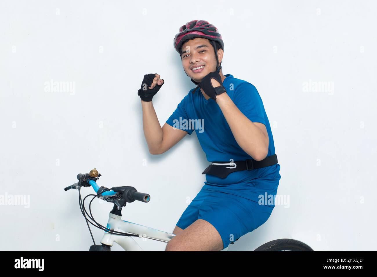 Junge asiatische Mann Radfahrer schütteln Fäuste isoliert auf weißem Hintergrund Stockfoto
