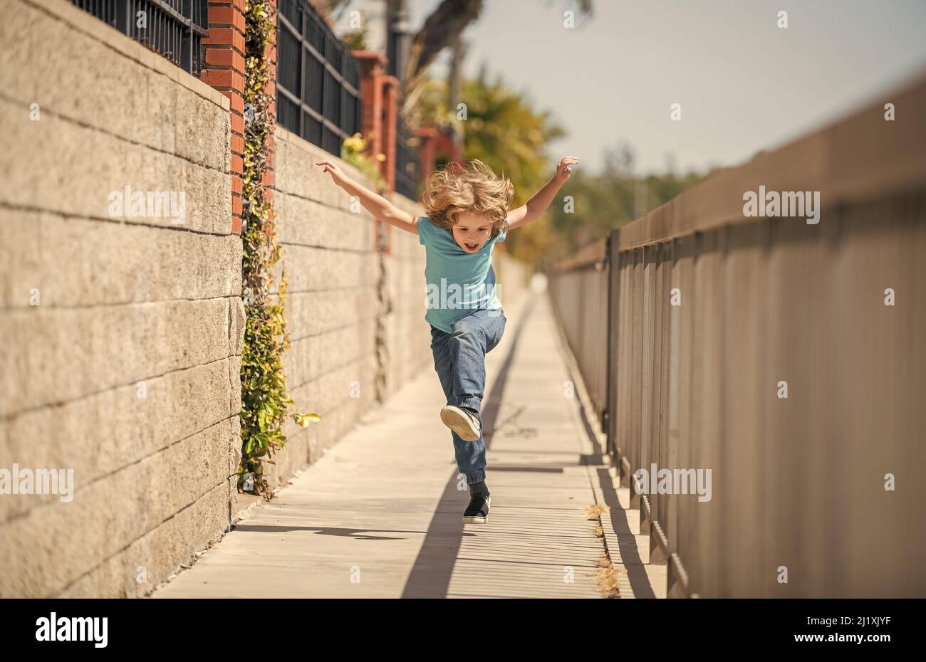 Wenn Sie ein aktives Leben führen, seien Sie glücklich und energisch. Energischer Kinderlauf auf der Promenade. Spaß in der Kindheit Stockfoto