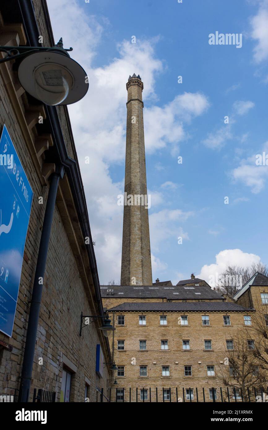 Dean Clough in Halifax, Calderdale, West Yorkshire, England, ist eine Gruppe von großen Fabrikgebäuden, die in den Jahren 1840s bis 60s für Crossley's Teppiche gebaut wurden und zu einer der größten Teppichfabriken der Welt wurden (eine halbe Meile lang mit 1.250.000 Quadratfuß (116.000 m2) Grundfläche). Nach Jahren rückläufiger Produktion schloss es 1983, als es von einem Konsortium unter der Leitung von Sir Ernest Hall gekauft wurde, das die denkmalgeschützte Stätte für verschiedene kommerzielle und kulturelle Zwecke entwickelte. Es gilt heute als ein führendes Beispiel für eine erfolgreiche Stadterneuerung.Dean Clough befindet sich auf der Nordseite von Halifax in der Nähe der V Stockfoto