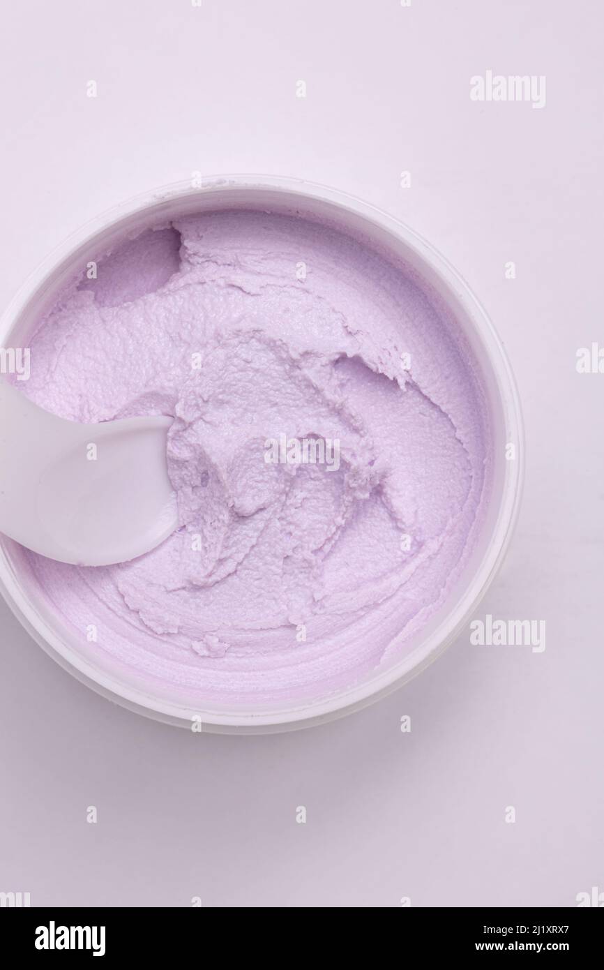 Draufsicht auf ein weißes Glas mit einer sanften Gesichtscreme. Stockfoto