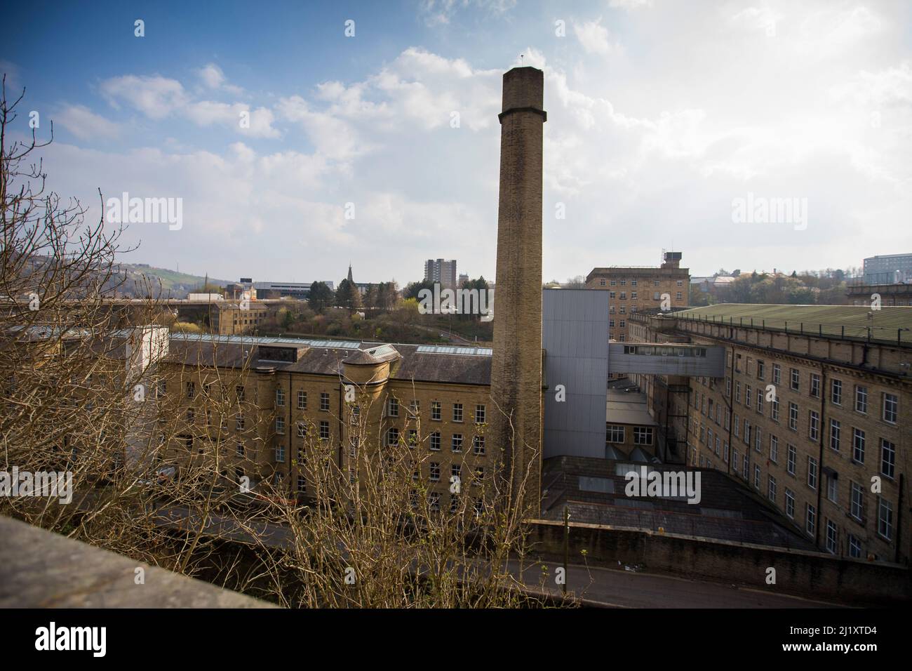 Dean Clough in Halifax, Calderdale, West Yorkshire, England, ist eine Gruppe von großen Fabrikgebäuden, die in den Jahren 1840s bis 60s für Crossley's Teppiche gebaut wurden und zu einer der größten Teppichfabriken der Welt wurden (eine halbe Meile lang mit 1.250.000 Quadratfuß (116.000 m2) Grundfläche). Nach Jahren rückläufiger Produktion schloss es 1983, als es von einem Konsortium unter der Leitung von Sir Ernest Hall gekauft wurde, das die denkmalgeschützte Stätte für verschiedene kommerzielle und kulturelle Zwecke entwickelte. Es gilt heute als ein führendes Beispiel für eine erfolgreiche Stadterneuerung.Dean Clough befindet sich auf der Nordseite von Halifax in der Nähe der V Stockfoto