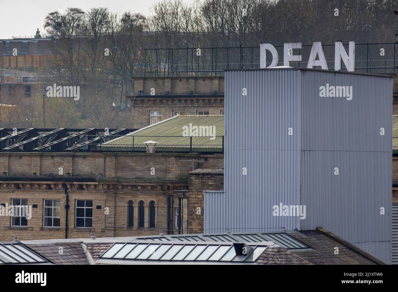 Dean Clough in Halifax, Calderdale, West Yorkshire, England, ist eine Gruppe von großen Fabrikgebäuden, die in den Jahren 1840s bis 60s für Crossley's Teppiche gebaut wurden und zu einer der größten Teppichfabriken der Welt wurden (eine halbe Meile lang mit 1.250.000 Quadratfuß (116.000 m2) Grundfläche). Nach Jahren rückläufiger Produktion schloss es 1983, als es von einem Konsortium unter der Leitung von Sir Ernest Hall gekauft wurde, das die denkmalgeschützte Stätte für verschiedene kommerzielle und kulturelle Zwecke entwickelte. Es gilt heute als ein führendes Beispiel für eine erfolgreiche Stadterneuerung.Dean Clough befindet sich auf der Nordseite von Halifax in der Nähe der V Stockfoto