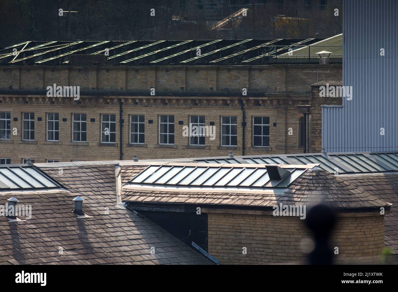 Dean Clough in Halifax, Calderdale, West Yorkshire, England, ist eine Gruppe von großen Fabrikgebäuden, die in den Jahren 1840s bis 60s für Crossley's Teppiche gebaut wurden und zu einer der größten Teppichfabriken der Welt wurden (eine halbe Meile lang mit 1.250.000 Quadratfuß (116.000 m2) Grundfläche). Nach Jahren rückläufiger Produktion schloss es 1983, als es von einem Konsortium unter der Leitung von Sir Ernest Hall gekauft wurde, das die denkmalgeschützte Stätte für verschiedene kommerzielle und kulturelle Zwecke entwickelte. Es gilt heute als ein führendes Beispiel für eine erfolgreiche Stadterneuerung.Dean Clough befindet sich auf der Nordseite von Halifax in der Nähe der V Stockfoto