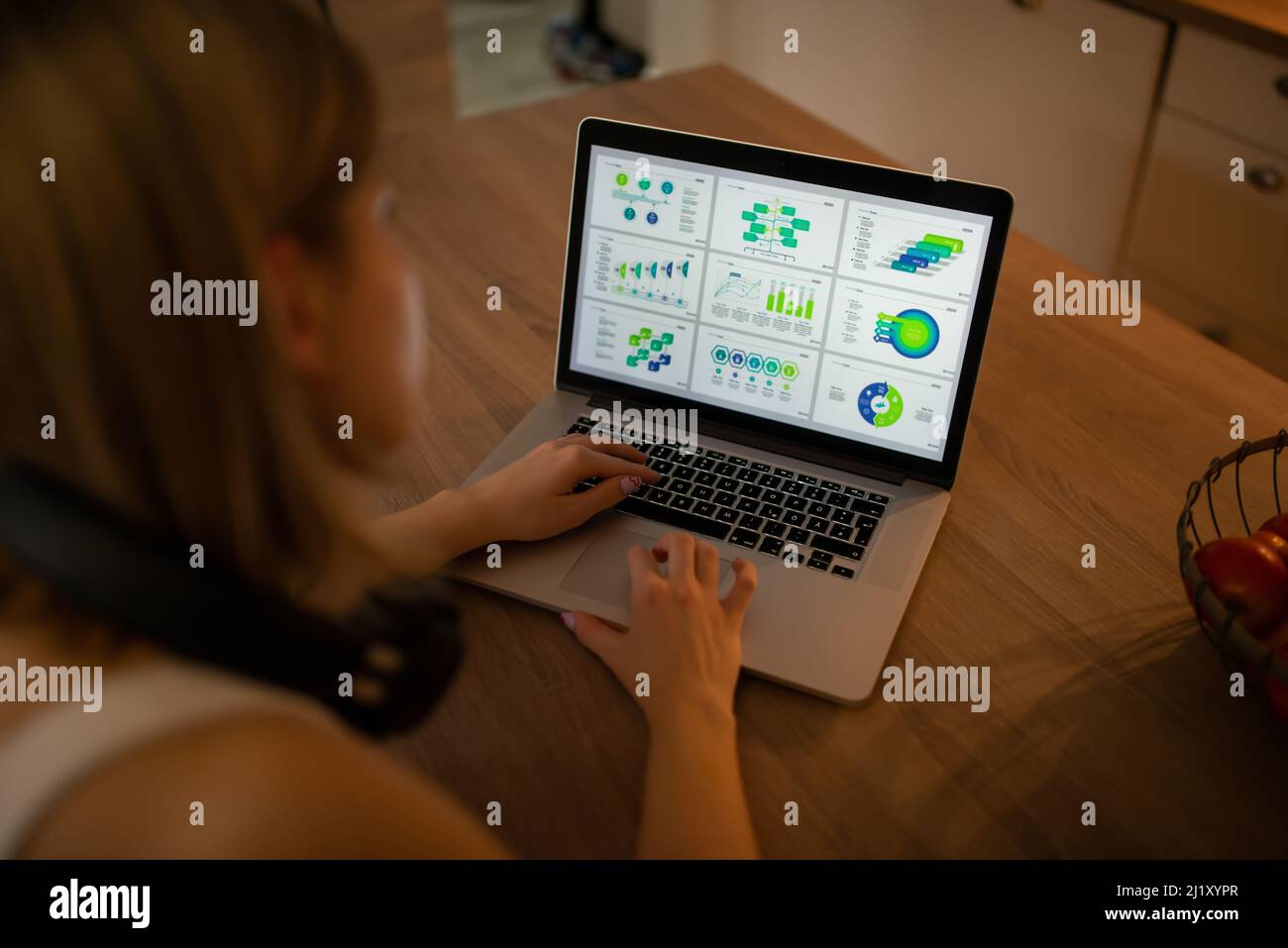 Eine junge, fleißige Frau arbeitet von zu Hause aus an neuen Projekten und ermittelt auf ihrem neuen Laptop Statistiken Stockfoto