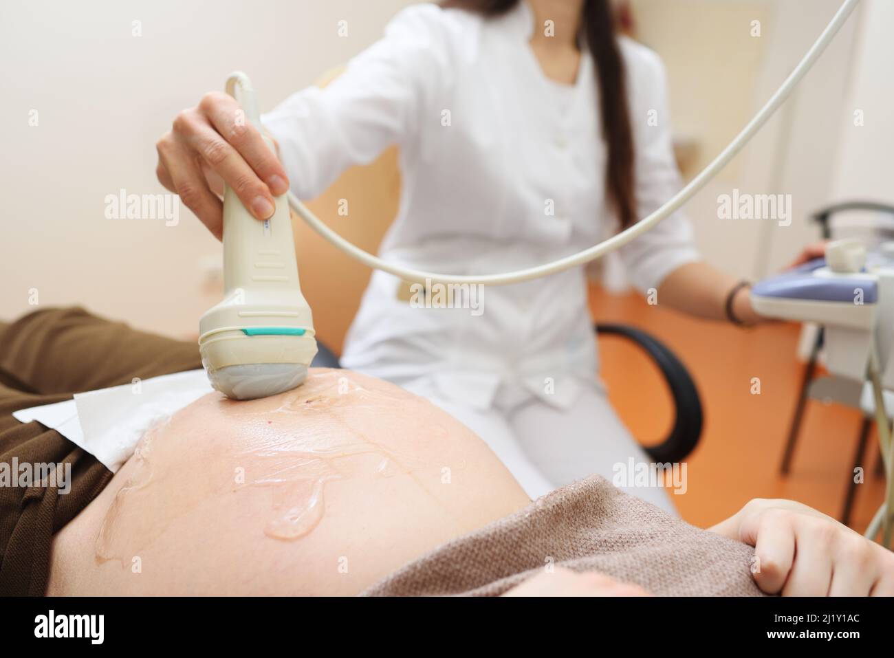 Der Arzt führt in einer modernen Klinik eine Ultraschalluntersuchung des Unheils einer Schwangeren durch. Stockfoto