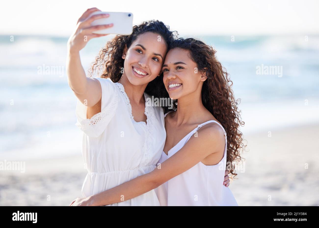 Wie glücklich bin ich, sie in meinem Leben zu haben. Aufnahme von zwei jungen Frauen, die am Strand Selfies machen. Stockfoto