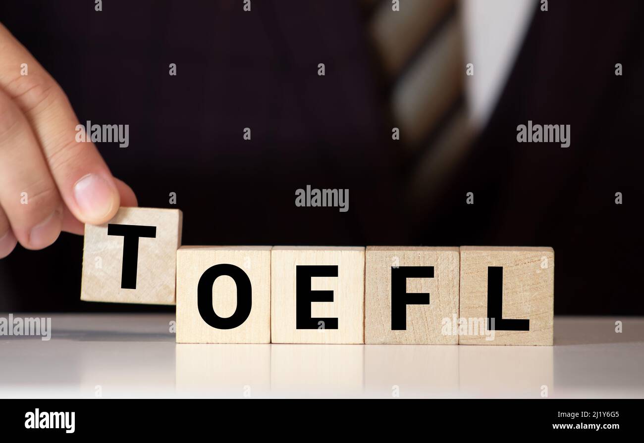 TOEFL - Wörter aus Holzblöcken mit Buchstaben, der Test des Englischen als Fremdsprache, TOEFL-Konzept, weißer Hintergrund. Stockfoto