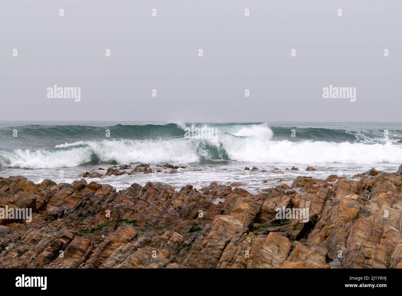 Meeresbrause, brechende Wellen an Felsküsten, anschwellen Energie an der Küste. Meeresenergie bei hohen Gezeiten. Meer- oder Playa-Themen mit Felsen und Wellen. Stockfoto