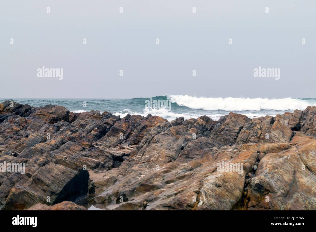 Meeresbrause, brechende Wellen an Felsküsten, anschwellen Energie an der Küste. Meeresenergie bei hohen Gezeiten. Meer- oder Playa-Themen mit Felsen und Wellen. Stockfoto