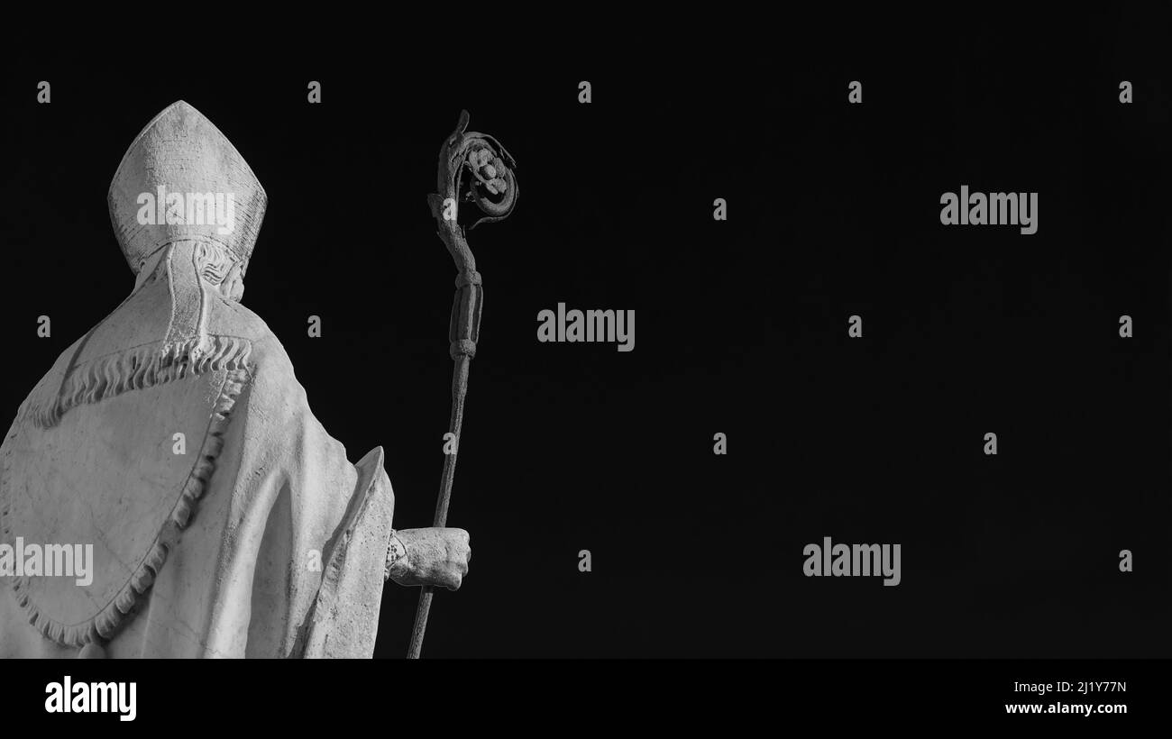 Katholische Kirche. Bischof mit Mitra und Bischofsstab, eine alte Statue aus weißem Marmor auf alten Mauern von Lucca, errichtet im 17th. Jahrhundert (Schwarz-Weiß mit Kopie Stockfoto