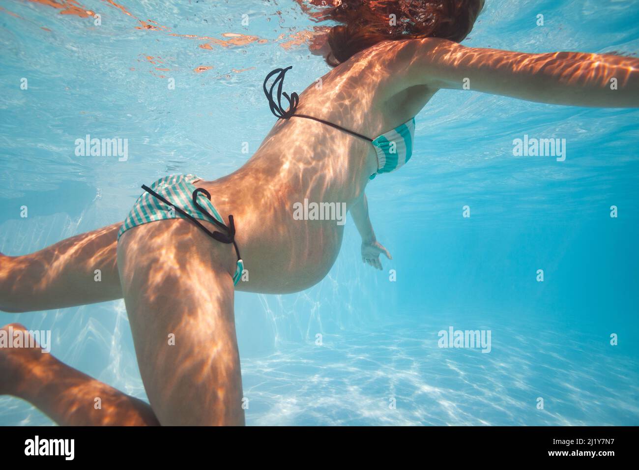 Schwanger Frau schwimmen im Außenpool unter Wasser Stockfoto