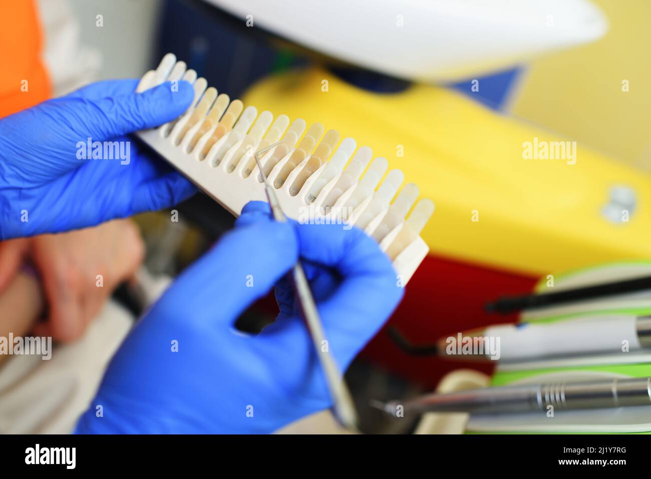 Der Zahnarzt wählt auf speziellen Geräten den richtigen Zahnfarbton aus. Stockfoto