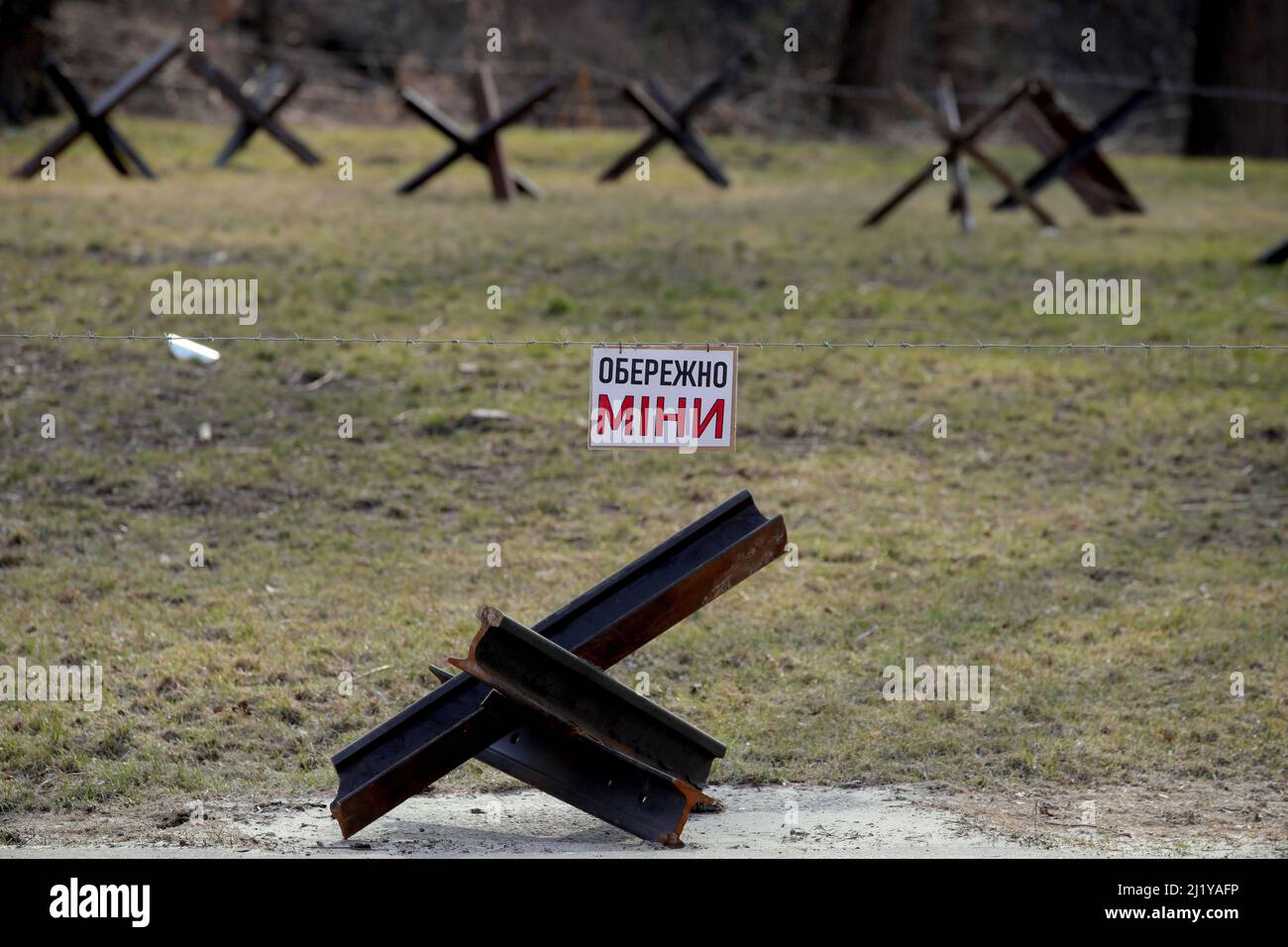 KIEW, UKRAINE - 28. MÄRZ 2022 - hinter einem Panzerabwehrhindernis, bekannt als tschechischer Igel, an einer Straßensperre, Kiew, ca. Stockfoto