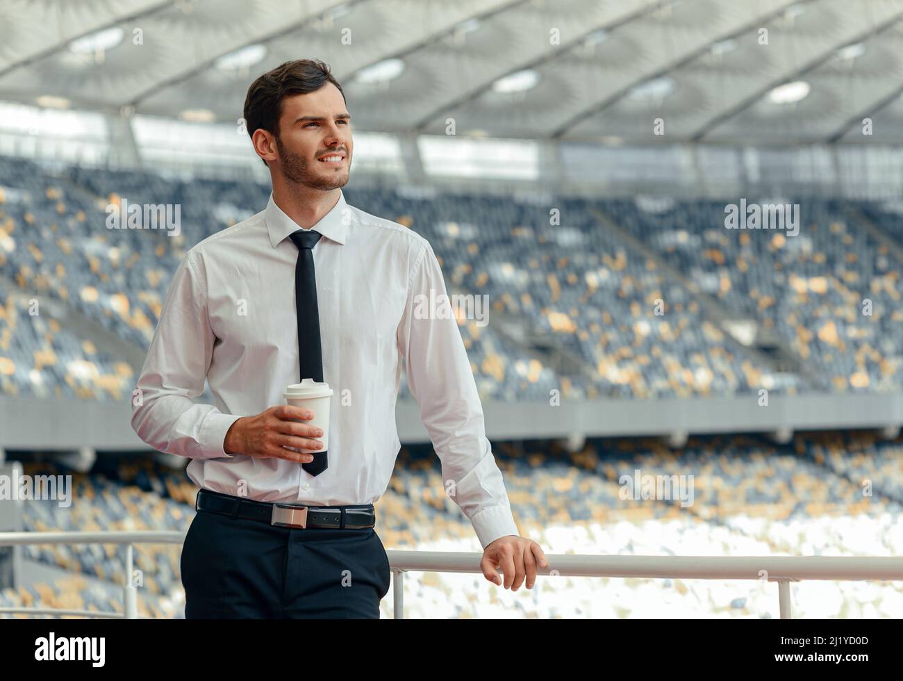 Porträt eines jungen Geschäftsmannes, der auf der Aussichtsplattform des Stadions steht Stockfoto