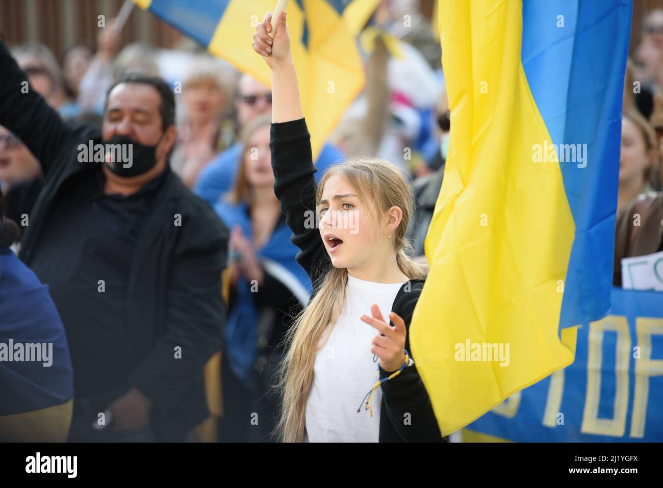 Nikosia, Zypern - 27. März 2022: Junge Protesterin schreit mit ukrainischer Flagge bei einer Kundgebung gegen die russische Invasion in die Ukraine Stockfoto