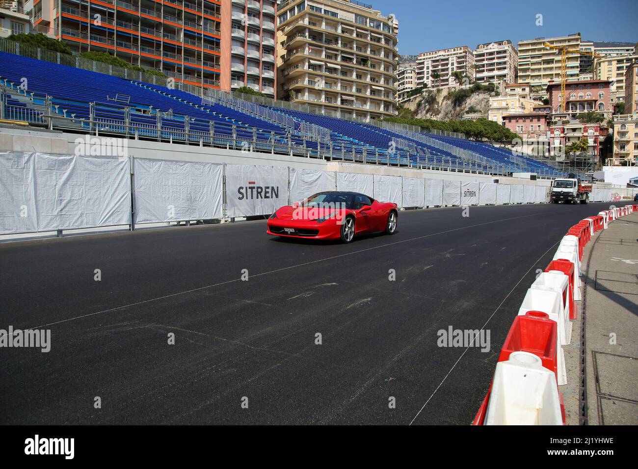 Monte Carlo, Monoco. 28 Mär 2022 - Ein Ferrari-Auto fährt an einem Stand vorbei, während Arbeiter sich auf das Rennen der Monte Carlo Grand Prix Formel 1 vorbereiten. Das Rennen findet am 29. Mai 2022 statt. Credit Dinendra Haria /Alamy Live News Stockfoto