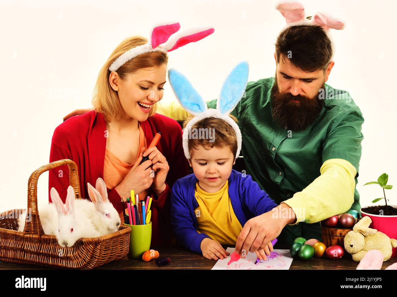 Mutter, Vater und Sohn mit Osterhasen. Glückliche Eltern mit Kind, die sich auf Ostern vorbereiten. Stockfoto