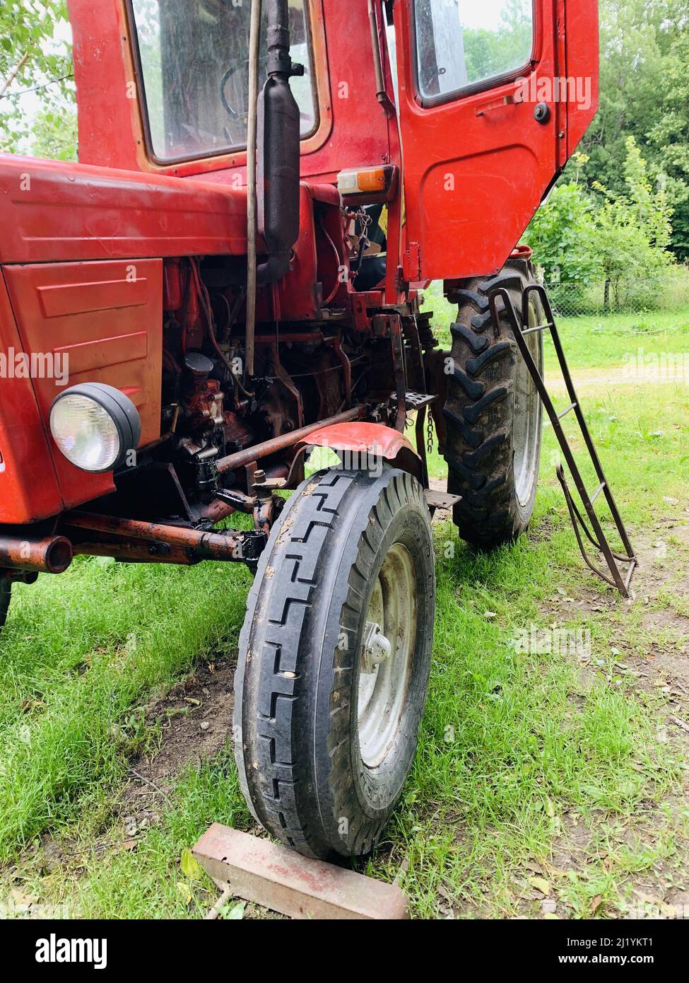 Eine vertikale Aufnahme eines roten Traktors in einem ländlichen Gebiet Stockfoto