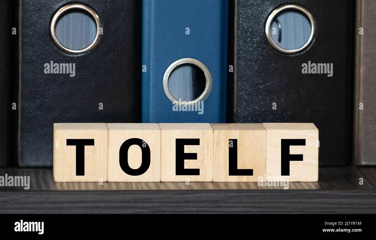 TOEFL - Wörter aus Holzblöcken mit Buchstaben, der Test des Englischen als Fremdsprache, TOEFL-Konzept, weißer Hintergrund Stockfoto