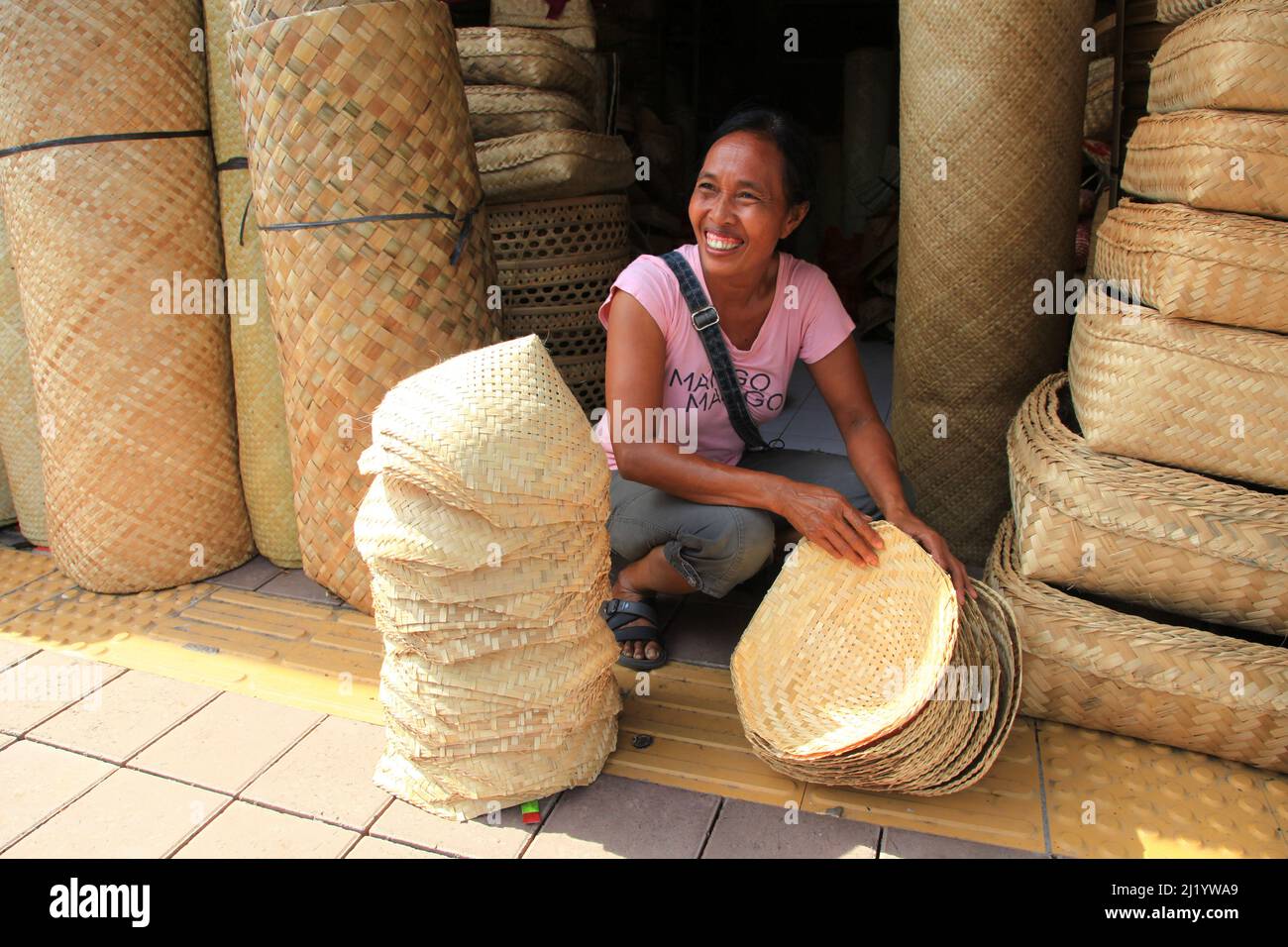 Ein lokaler Verkäufer, der Rattankörbe und -Hüte auf dem Sukawati Markt in Sukawati, Gianyar, Bali verkauft. Stockfoto