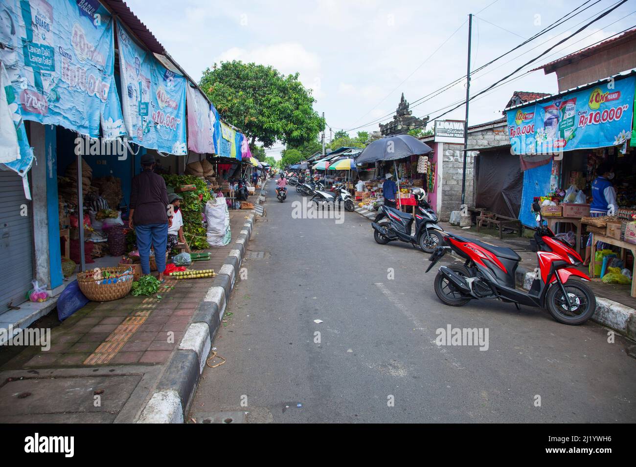 Eine Straße in Sukawati, gesäumt von Geschäften, die lokale Produkte, Gemüse usw. in Bali, Indonesien, verkaufen. Stockfoto