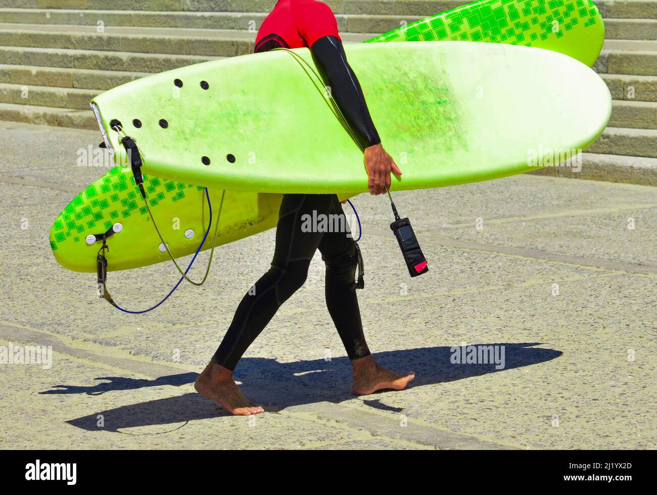Surfer im Anzug nach der Schulung und in Händen hält Surfboards. Lehrer in einem serf Schule Stockfoto