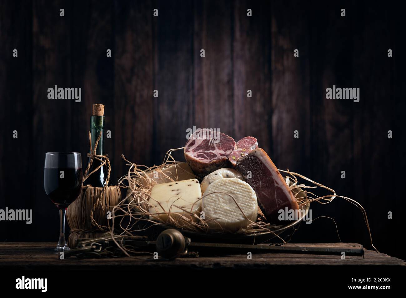 Verschiedene hausgemachte Käse, Salumi auf Holztisch mit einem Holzhintergrund. Nahaufnahme Stockfoto