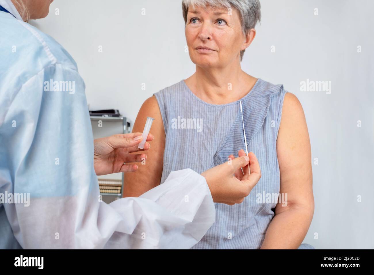 Der Arzt erklärt dem älteren Patienten, wie ein pcr-Test im Büro durchgeführt wird Stockfoto