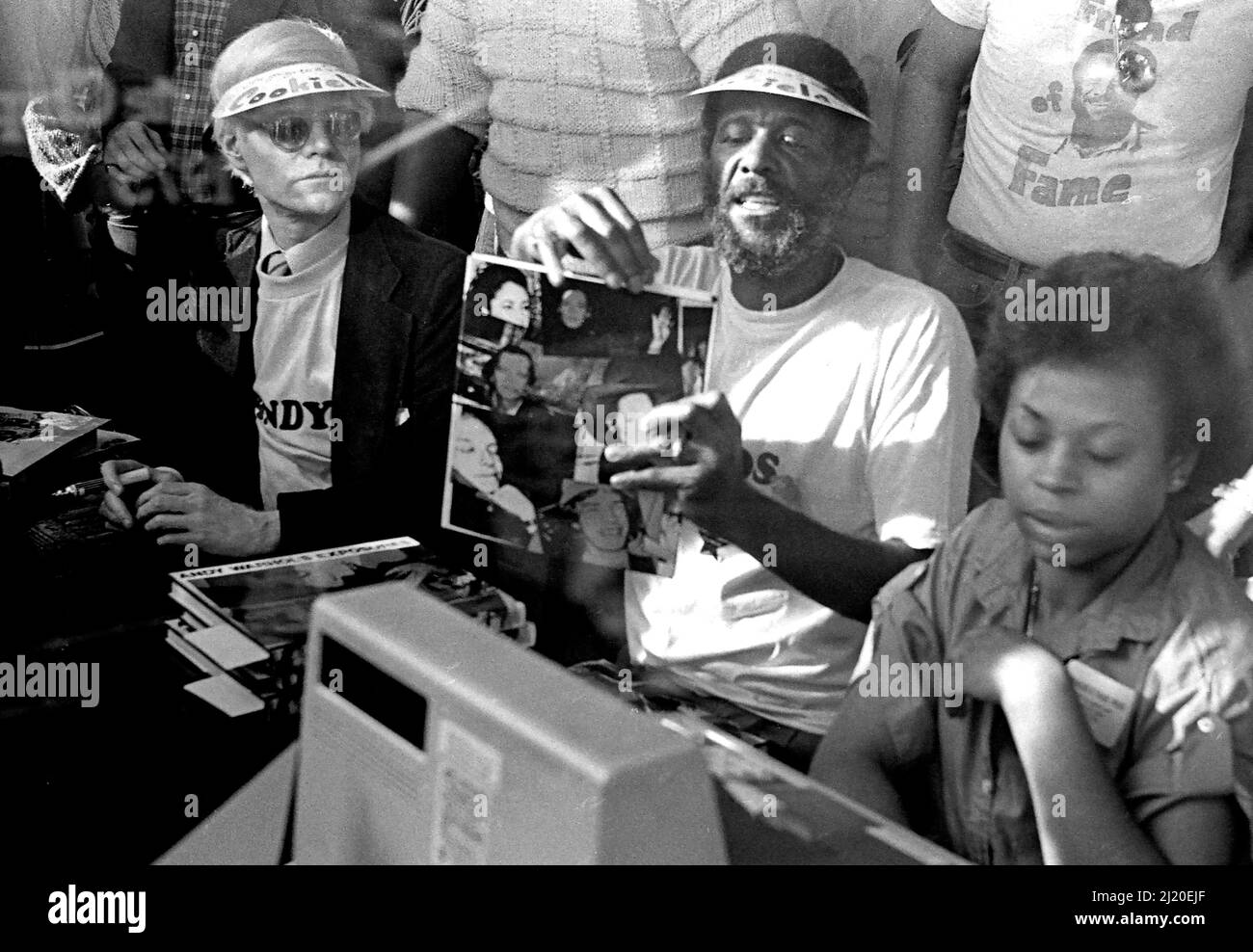 Eine Veranstaltung, die im Hollywood Outlet als „Amos und Andy“ für die berühmten Amos Cookies, Andy Warhol und Wally Amos bezeichnet wird, signiert Bücher neben einer Kasse. Los Angeles, Kalifornien, 1979. Stockfoto
