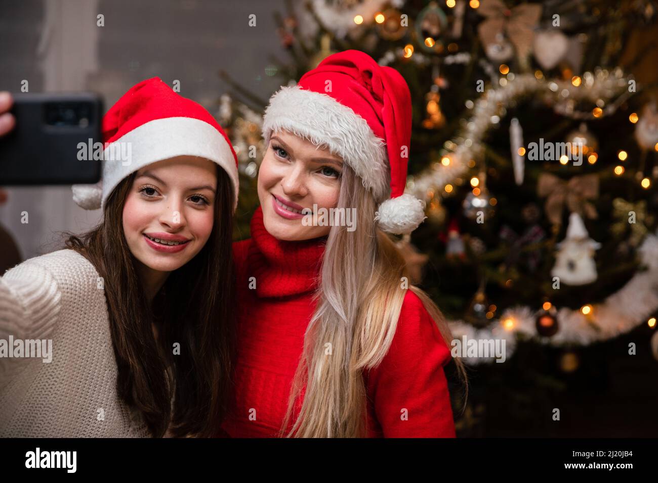 Mutter und Tochter machen ein Selfie, nachdem sie den Weihnachtsbaum dekoriert haben. Stockfoto