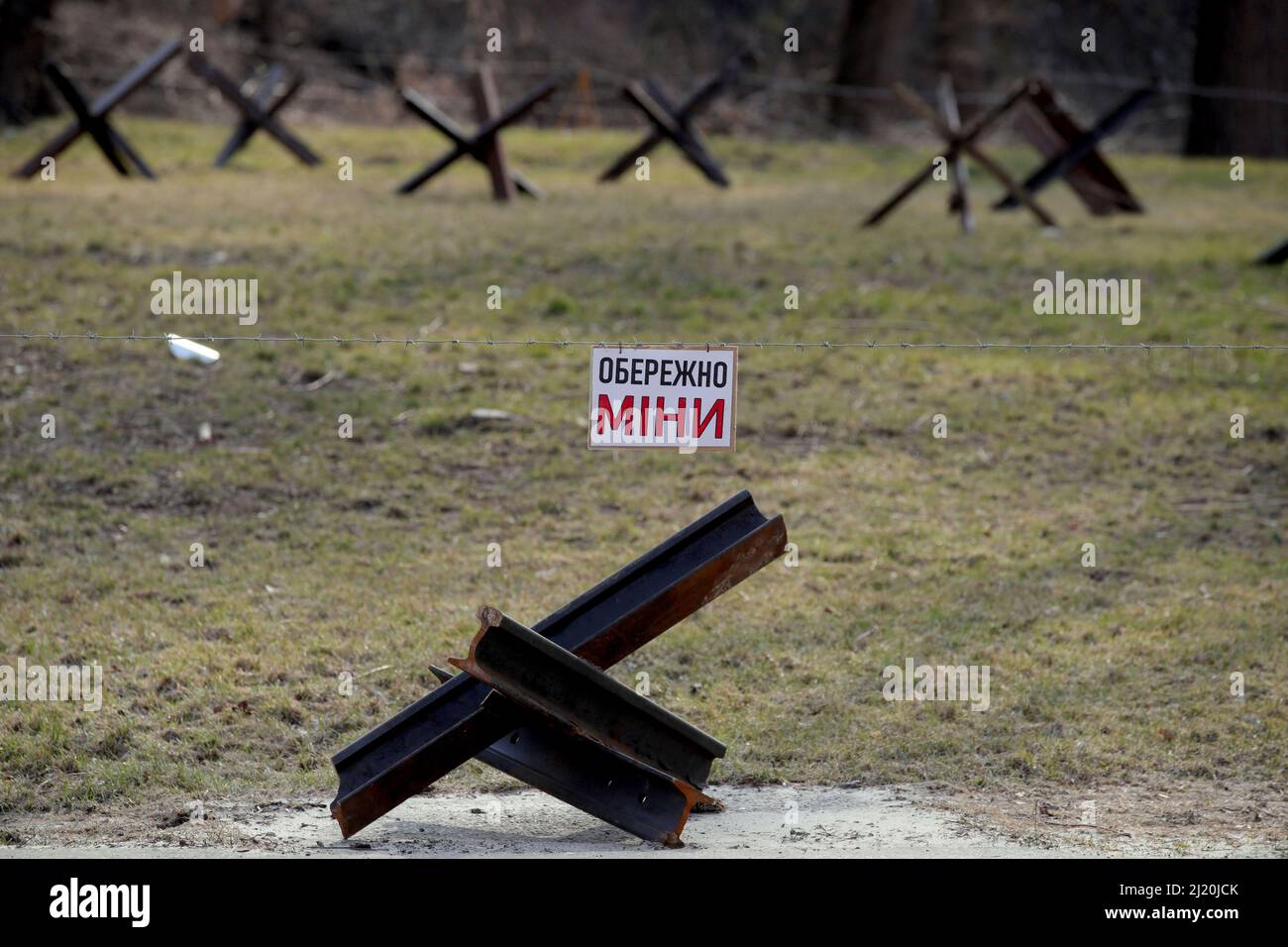 Das Schild mit der Warnung vor Minen befindet sich hinter einem Panzerabwehrhindernis, bekannt als tschechischer Igel, an einer Straßensperre, Kiew, Hauptstadt der Ukraine, 28. März, 2022. Foto von Pavlo Bagmut/Ukrinform/ABACAPRESS.COM Stockfoto