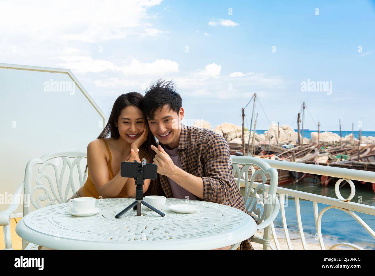 Junges Paar chattet mit dem Handy im Restaurant Ocean View - Stock photo Stockfoto