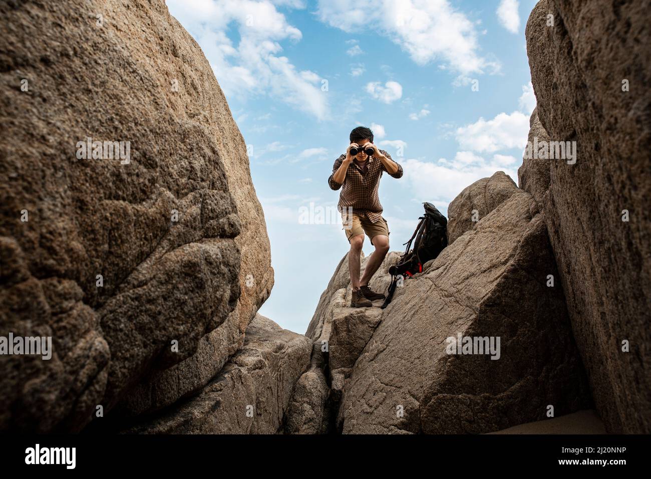 Wildnisforscher, der weit weg durch das Teleskop im felsigen Tal schaut. - Stock Foto Stockfoto