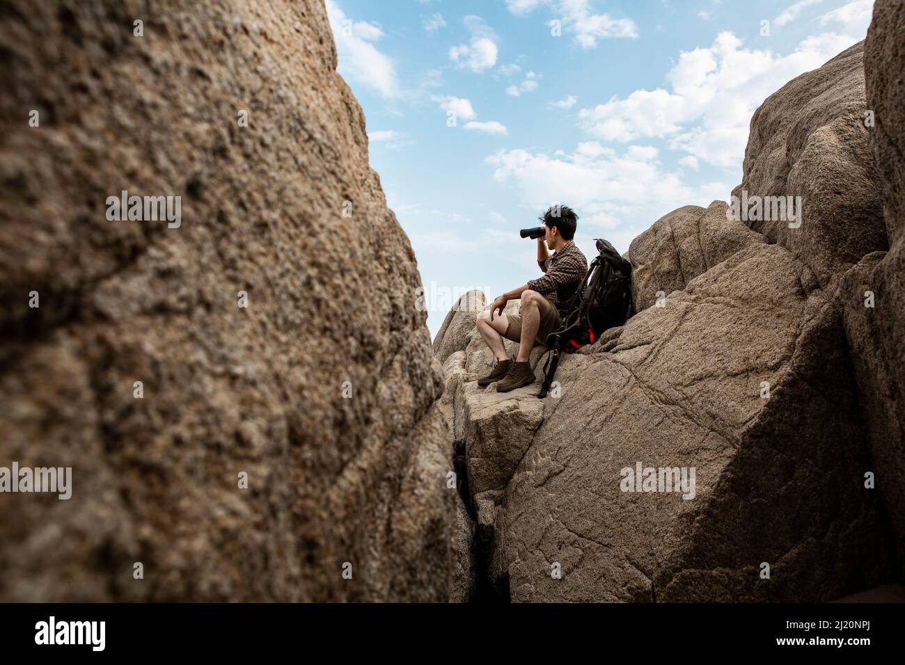 Wildnisforscher, der weit weg durch das Teleskop im felsigen Tal schaut. - Stock Foto Stockfoto