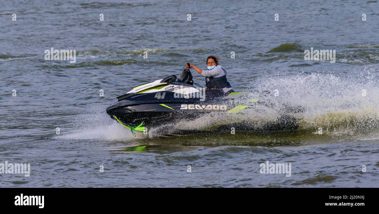 Nuwara Eliya, Sri Lanka - 02 16 2022: Frauen fahren auf einem Jetski in Gregory Lake. Wasser spritzt, während sie Stunts im Wasser durchführt. Stockfoto