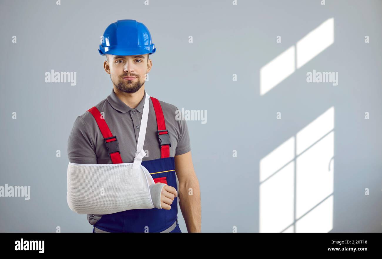 Porträt eines jungen Baumeisters, der sich bei einem Arbeitsunfall auf der Baustelle den Arm gebrochen hat Stockfoto