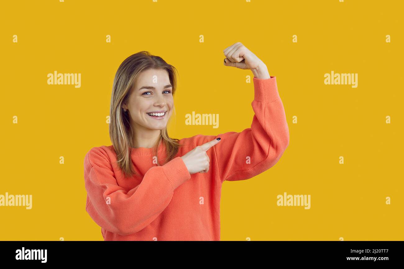 Glückliche schöne junge Frau lächelt und biegt ihren Arm zur Illustration Girl Power Concept Stockfoto