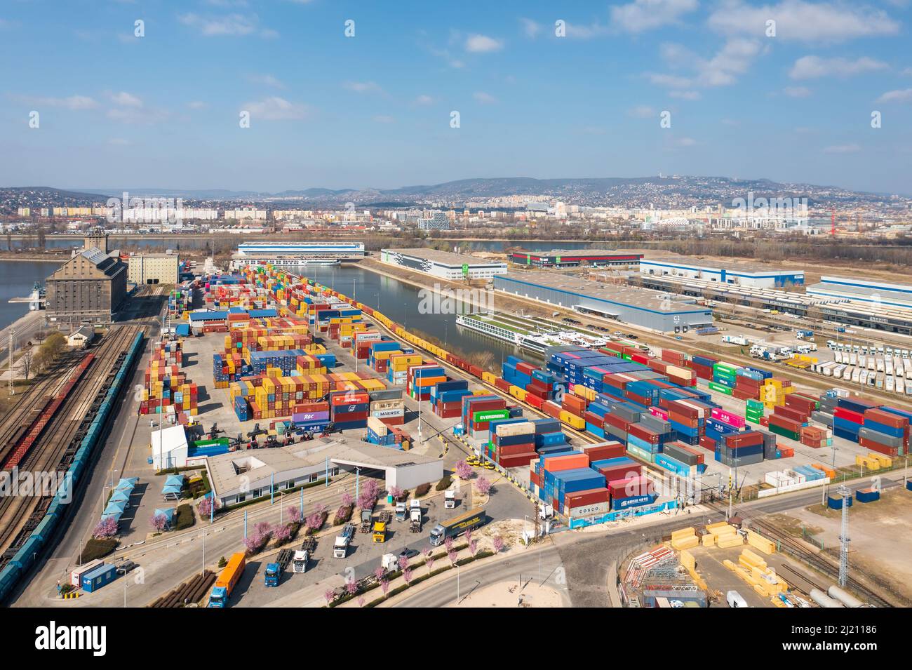 Luftaufnahme über Budapest freeport mit leeren Containern, die auf den Transport warten. Donau im Hintergrund. Import, Export der Industrie. Stockfoto