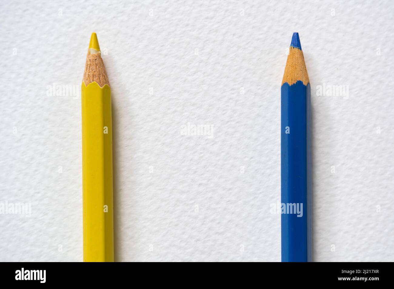 Blaue und gelbe Buntstifte auf rauem Papier. Blau und Gelb sind die Farben der ukrainischen Nationalflagge. Stockfoto