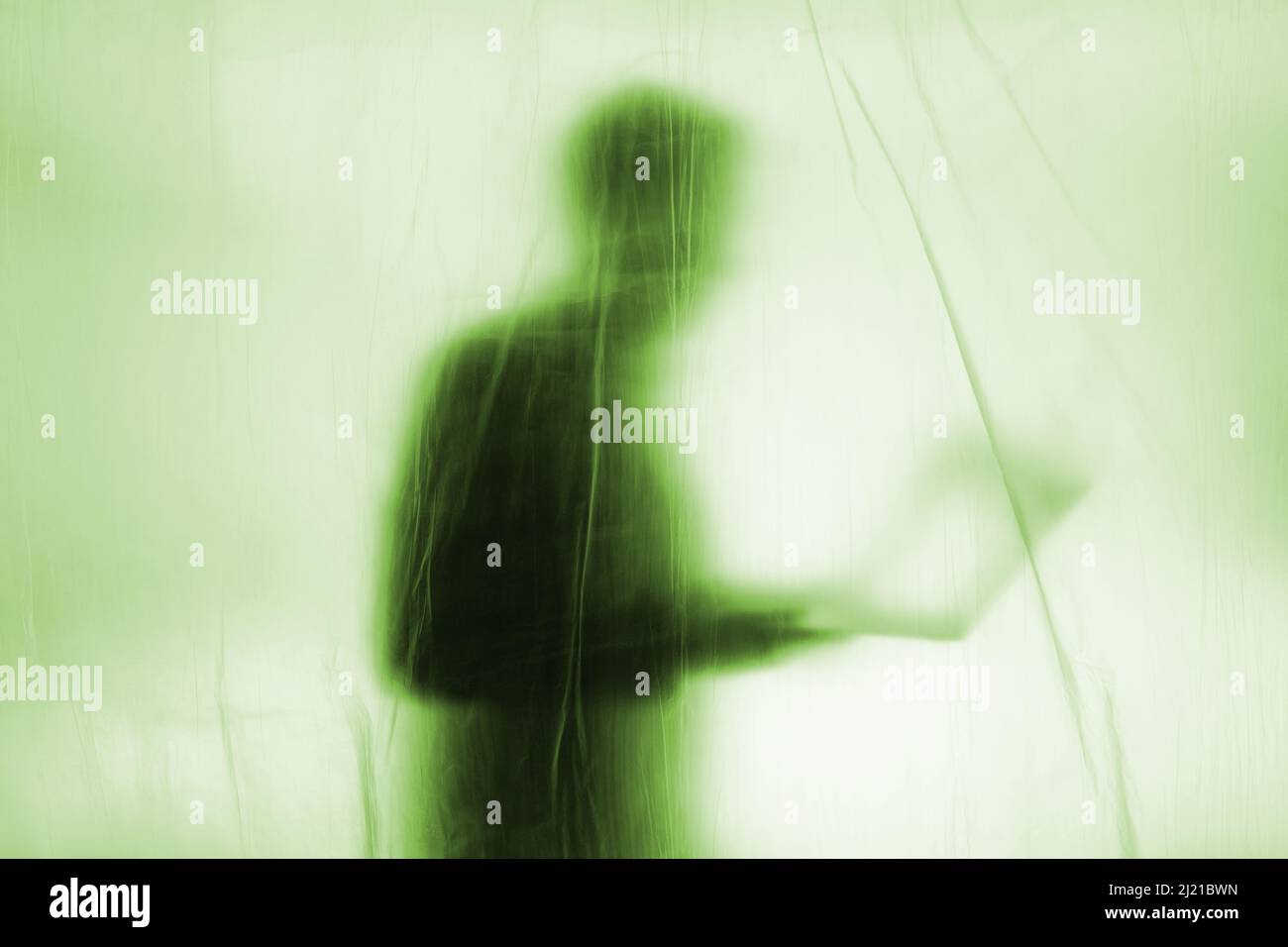Anonymous Hacker begeht Cyberkriminalität mit einem Laptop in der Hand Stockfoto