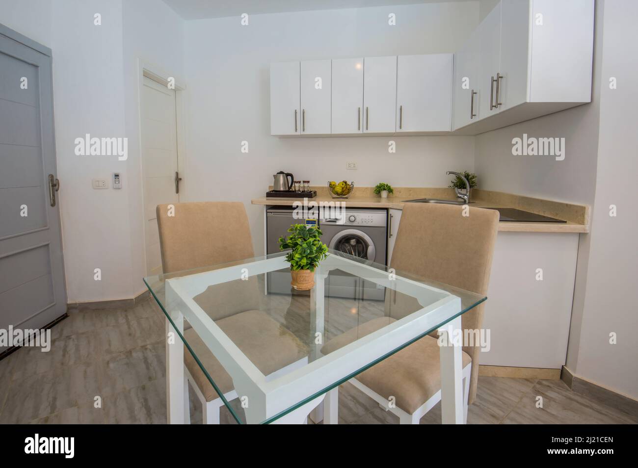 Inneneinrichtung mit moderner Küche und Geräten in einem luxuriösen Apartment-Showroom mit Esstisch Stockfoto