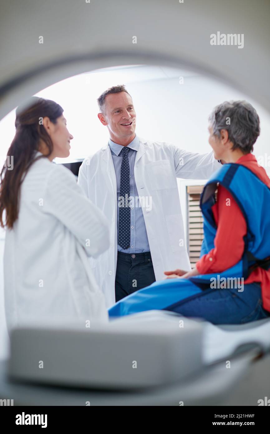 Ich habe einige tolle Neuigkeiten für Sie. Aufnahme einer reifen Frau, die vor dem Gespräch mit Ärzten und einer MRT-Untersuchung sprach. Stockfoto
