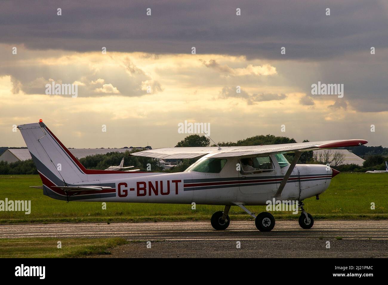 Cessna 152 Flugzeug G-BNUT Durchführung von Motorleistungskontrollen vor dem Rollout und Start am Southend Airport, Essex, Großbritannien, spät am Nachmittag. Stockfoto