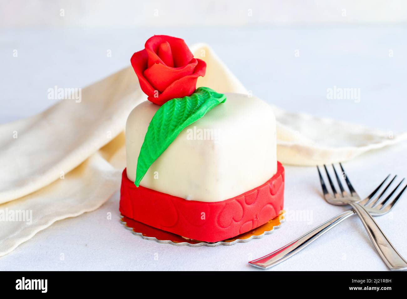 Kuchen im Herzdesign auf weißem Hintergrund. Kuchen im besonderen Design zum Valentinstag und Muttertag. Stockfoto
