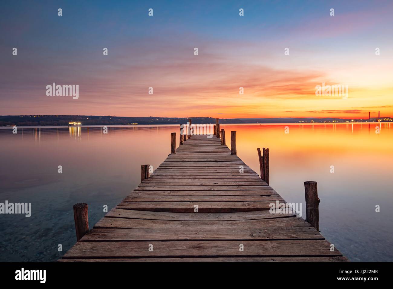 Kleines Dock oder hölzerner Pier und der See bei Sonnenuntergang Stockfoto