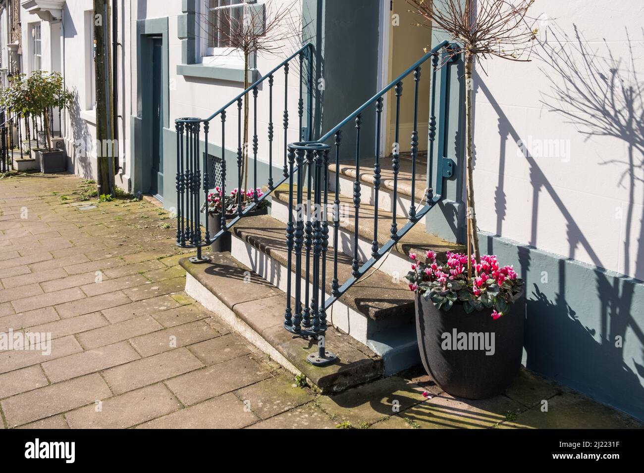 Steintreppen führen bis zur Eingangstür eines Hauses mit dekorativen Handgeländern in Modbury, South Hams, Devon Stockfoto