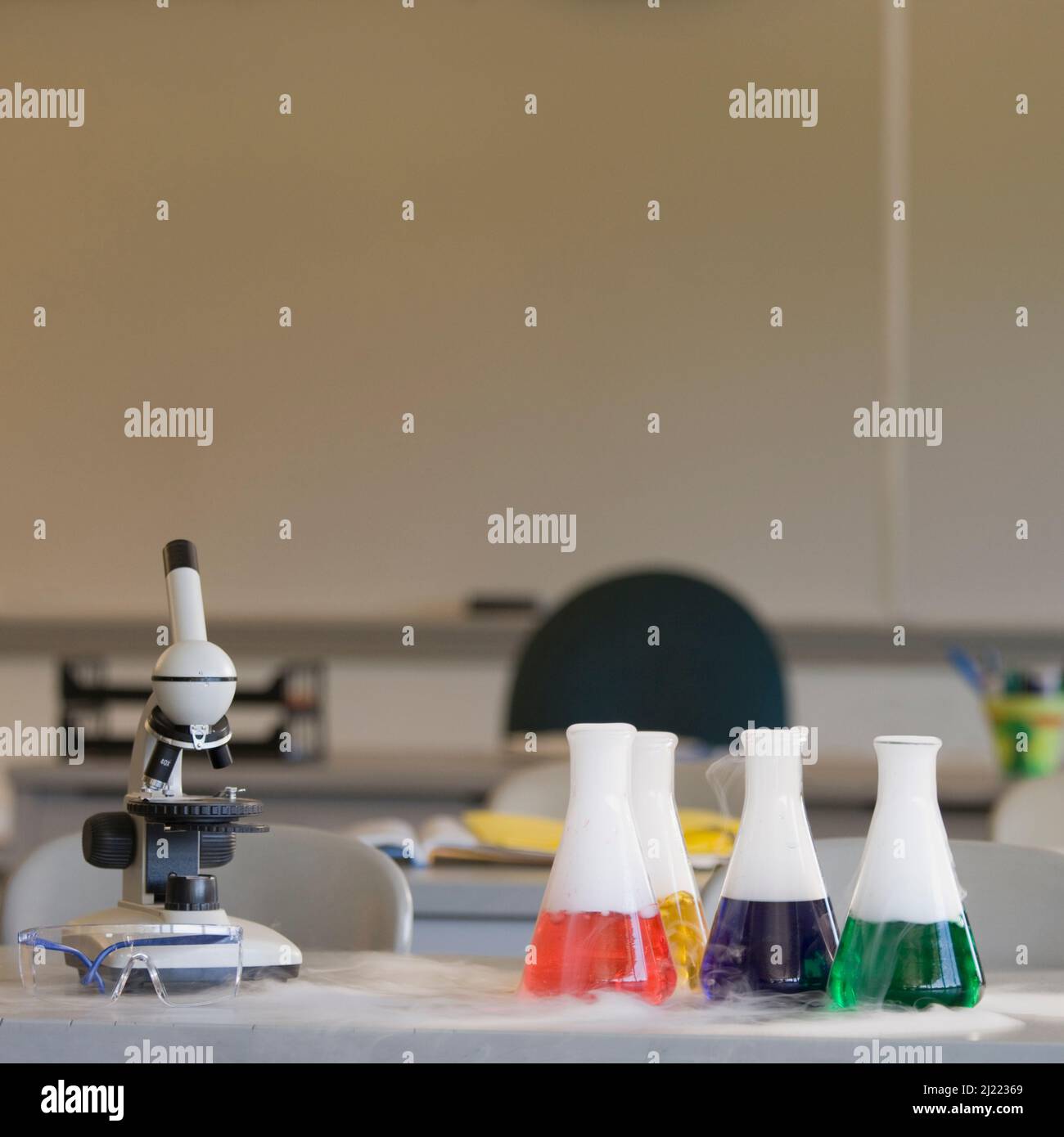 Chemische Geräte auf Labortisch, Mikroskop und Bechergläsern. Stockfoto