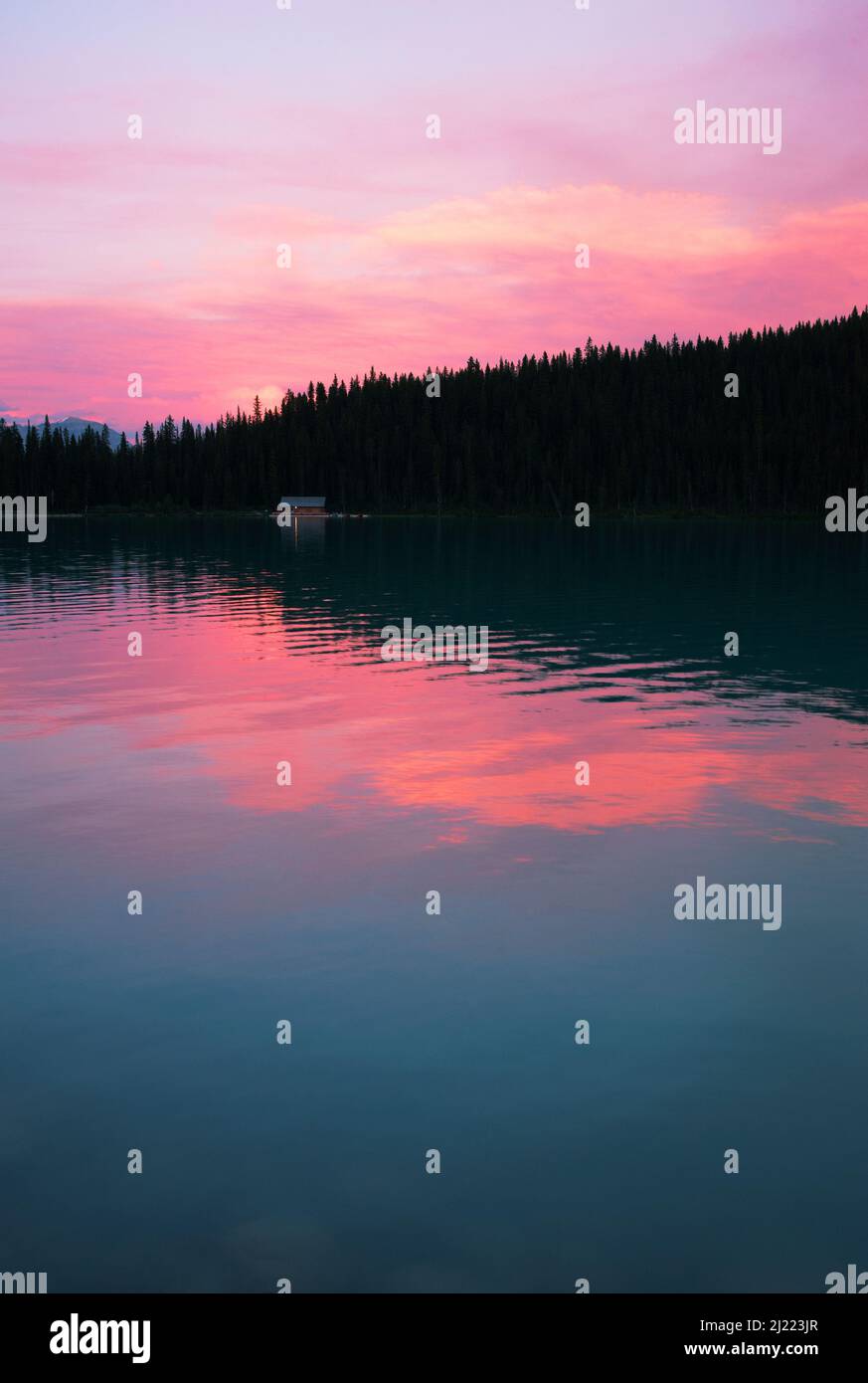 Lake Louise mit Reflexen des rosafarbenen Himmels bei Sonnenuntergang. Stockfoto