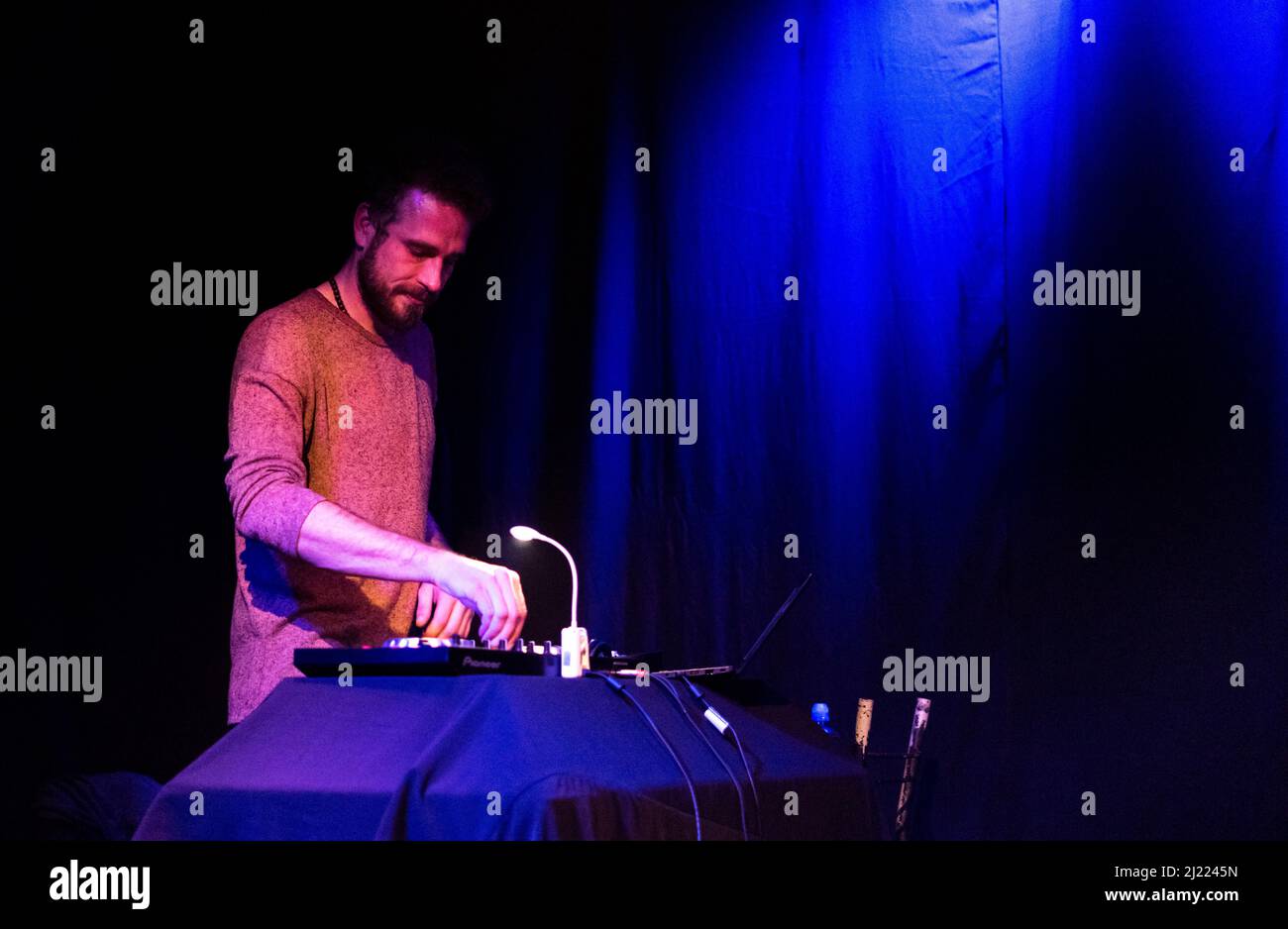 Ein hübscher und kunstlicher DJ, der während eines Konzerts coole Musik spielt Stockfoto